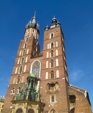 Krakow, Polonya - Güneşli bir öğleden sonra, Krakow 'un ana meydanında St. Marys Kilisesi' nin cephesi.