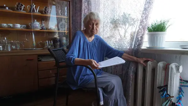 Starší Žena Držící Účet Plyn Před Topným Radiátorem Platba Vytápění — Stock fotografie