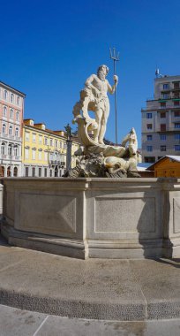 Trieste, İtalya - 1 Ekim 2023: Trieste, İtalya - ünlü Piazza della Borsa 'da Neptün heykeli. Sol tarafta ve sütunları olan tarihi bir bina. Arka planda mavi gökyüzü.