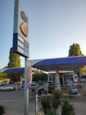OSTUNI, İtalya - 2 Ekim 2023: Otoyolda benzin ve dizel yakıtı fiyatları sergilenen Q8 benzin istasyonunun bayrağı