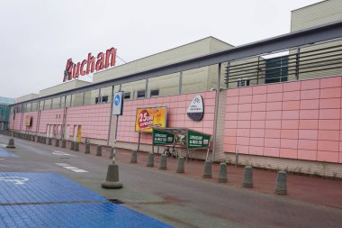 Wroclaw, Polonya - 19 Ekim 2023: Fransız süpermarketi Auchan kırmızı logosu alışveriş merkezinin üstünde