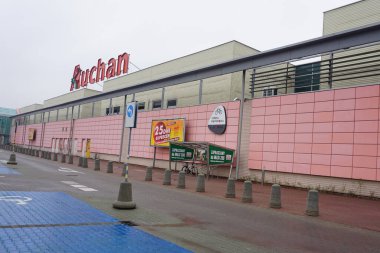 Wroclaw, Poland - October 19, 2023: French supermarket Auchan red logo on top of the shopping centre clipart