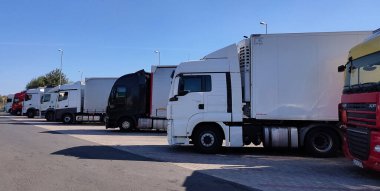 Wroclaw, Polonya - 17 Nisan 2023: Kamyonlar ve yarı tırlar otoparka gider. Teslimat kamyonları. Kargo Nakliyesi. - Lorry. Endüstriyel Taşımacılık Lojistik Taşımacılık Konsepti.