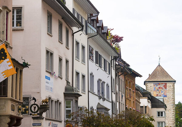 Schaffhausen, Switzerland - October 21, 2023: Beautiful facades of historic houses at the old town of Swiss City of Schaffhausen on a foggy day at Schaffhausen, Switzerland on October 21, 2023