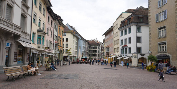 Schaffhausen, Switzerland - October 21, 2023: People going at the old town of Swiss City of Schaffhausen on a foggy day at Schaffhausen, Switzerland on October 21, 2023