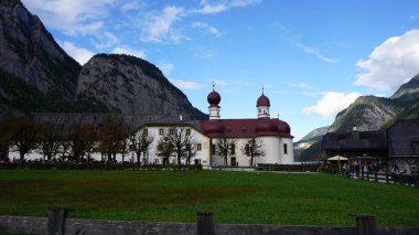 Konigsee, Almanya - 22 Ekim 2023: Almanya 'da sonbaharda Konigsee Ulusal Parkı' ndaki St. Bartholoma kilisesine giden insanlar