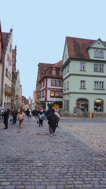 Rothenburg ob der Tauber, Almanya - 20 Ekim 2023: İnsanlar Rothenburg ob der Tauber 'deki tarihi binaların yakınına gidiyorlar - Almanya' nın eski güçlendirilmiş kenti.