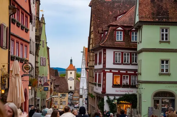 Rothenburg ob der Tauber, Almanya - 20 Ekim 2023: İnsanlar Rothenburg ob der Tauber 'deki tarihi binaların yakınına gidiyorlar - Almanya' nın eski güçlendirilmiş kenti.