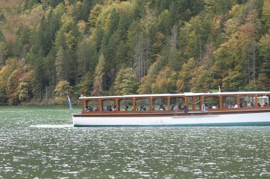 Konigsee, Almanya: 22 Ekim 2023 - dağlarla çevrili gölde dinlenen turistler, Berchtesgaden Ulusal Parkı, Bavyera, Almanya