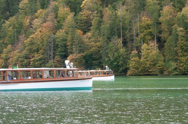 Konigsee, Almanya: 22 Ekim 2023 - dağlarla çevrili gölde dinlenen turistler, Berchtesgaden Ulusal Parkı, Bavyera, Almanya