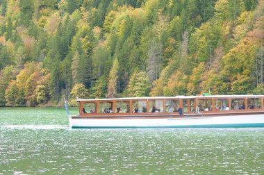 Konigsee, Almanya: 22 Ekim 2023 - dağlarla çevrili gölde dinlenen turistler, Berchtesgaden Ulusal Parkı, Bavyera, Almanya