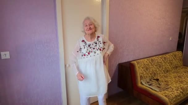 Щаслива Усміхнена Смішна Старша Жінка Білій Сукні Танцює Вдома — стокове відео