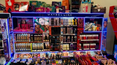 Rimini, İtalya - 25 Haziran 2024: Maybelline New York 'ta kadınların kozmetik ürünleri, ruj, kulak kirliliği, gölgeler. Satış fiyatlarına göre sezon alışverişi. Yoldan geçenler ve geçenler.
