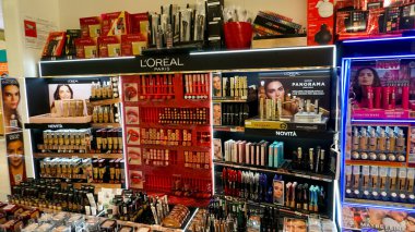 Rimini, İtalya - 25 Haziran 2024: Kadın kozmetik ürünleri, ruj, kulak kiri, gölgeli Loreal Paris mağazası. Satış fiyatlarına göre sezon alışverişi. Yoldan geçenler ve geçenler.