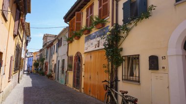 Rimini, İtalya - 25 Haziran 2024: Borgo San Giuliano 'da duvarda duvar resmi Rimini, İtalya' da alçak ve renkli evleri olan tipik bir sokak