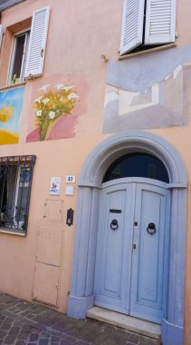 Rimini, İtalya - 25 Haziran 2024: Borgo San Giuliano 'da duvarda duvar resmi Rimini, İtalya' da alçak ve renkli evleri olan tipik bir sokak