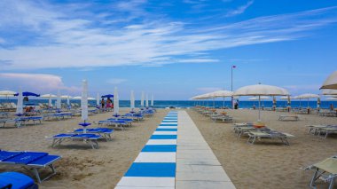Yaz. Boş sahildeki güneşlik ve şemsiyeler.