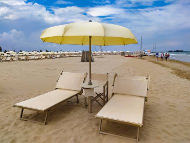 Yaz. Boş sahildeki güneşlik ve şemsiyeler.