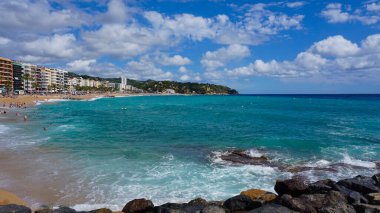 Lloret de mar, İspanya - 30 Eylül 2024: İnsanlar Lloret De Mar plajında dinleniyor. Güneşli bir günde Katalonya 'nın Costa Brava plajı