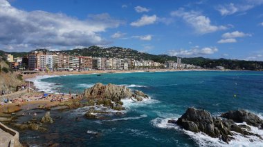 Lloret de mar, İspanya - 30 Eylül 2024: İnsanlar Lloret De Mar plajında dinleniyor. Güneşli bir günde Katalonya 'nın Costa Brava plajı