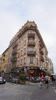 Nice, Fransa - 22 Eylül 2024: Şehrin göbeğindeki küçük meydanda dinlenen insanlar. Hemen hemen tüm koltukları dolu olan sokak kafeleri, eski kasabadaki şehir hayatı..