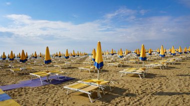 Venedik, Veneto bölgesi yakınlarındaki Lido di Jesolo plajında güneşli bir günde İtalya 'da şemsiyeler.