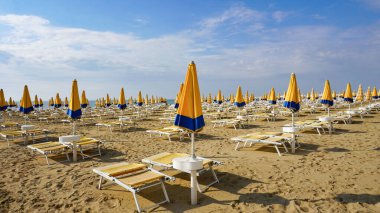 Venedik, Veneto bölgesi yakınlarındaki Lido di Jesolo plajında güneşli bir günde İtalya 'da şemsiyeler.