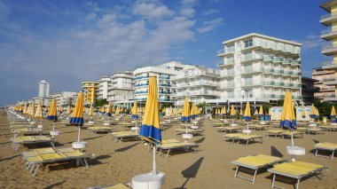 Venedik, Veneto bölgesi yakınlarındaki Lido di Jesolo plajında güneşli bir günde İtalya 'da şemsiyeler.