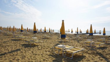 Venedik, Veneto bölgesi yakınlarındaki Lido di Jesolo plajında güneşli bir günde İtalya 'da şemsiyeler.