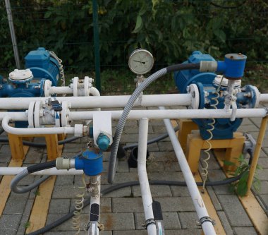 Bahar tarlaları arasında doğal gaz pompalama istasyonu. Sarı borular, basınç göstergeleri ve vanalar - doğal gaz nakil tesisinin elementleri .
