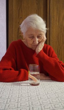 Yaşlı kadın ellerinde esnek naylon protez. Çıkarılabilir takma dişler esnek, naylondan yoksun, hipoalerjenik, monomerden muaf.