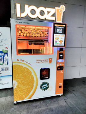 Singapur - 21 Ocak 2024: IJooz akıllı satış makinesi taze sıkılmış portakal suyu servis ediyor. iJooz, yapay zeka teknolojisi kullanan bir otomat şirketi..