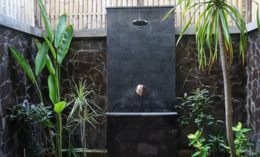 Yeşil egzotik bitkilerle süslenmiş modern açık hava duşu. Tropik açık hava duşu. Açık hava duş lüks villanın iç tasarımı