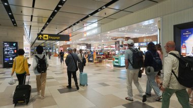 Singapur - 20 Ocak 2025: Singapur Changi Havalimanı 'na giden insanlar. Changi Havalimanı Singapur 'un birincil sivil havaalanıdır ve Güneydoğu Asya' nın en büyük ulaşım merkezlerinden biridir..
