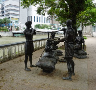 Singapur - 21 Ocak 2025 Nehir Tüccarları, Riverside Bot Heykelleri. Bir Avrupalı tüccar Çinli bir tüccar ve Malay şefiyle iş konuşurken işçilerin bir öküz arabasını yüklediğini resmediyor.