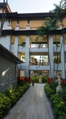 Nusa Dua, Bali, Endonezya - 18 Ocak 2025: Nusa Dua, Bali, Endonezya 'daki Grand Hyatt Bali tatil köyündeki otel binası ve tropikal ağaçlar.