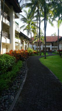 Nusa Dua, Bali, Endonezya - 18 Ocak 2025: Nusa Dua, Bali, Endonezya 'daki Grand Hyatt Bali tatil köyündeki otel binası ve tropikal ağaçlar.