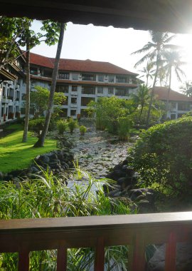 Nusa Dua, Bali, Endonezya - 18 Ocak 2025: Nusa Dua, Bali, Endonezya 'daki Grand Hyatt Bali tatil beldesinde tropikal ağaçlı lotus havuzu veya laguna.