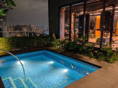 Singapur - 21 Ocak 2025: 21 Ocak 2025 tarihinde Singapur 'un Uzak Doğu Konukseverliği tarafından Singapur' daki The Clan Hotel 'de sonsuzluk yüzme havuzu. Havuzun modern iş gökdelenlerinin panoramik manzarası var.