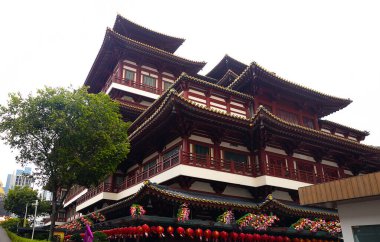  Singapur 'daki Buda Dişi Kalıntısı Tapınağı. Karmaşık kırmızı mimarisini sergiliyor. Bulutlu gökyüzüne karşı kontrastı