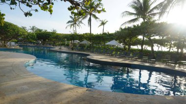 Nusa Dua, Bali, Endonezya - 18 Ocak 2025: Nusa Dua, Bali, Endonezya 'daki Grand Hyatt Bali tatil beldesinde tropik ağaçlarla yüzme havuzu