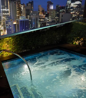 Singapur - 21 Ocak 2025: 21 Ocak 2025 tarihinde Singapur 'un Uzak Doğu Konukseverliği tarafından Singapur' daki The Clan Hotel 'de sonsuzluk yüzme havuzu. Havuzun modern iş gökdelenlerinin panoramik manzarası var.