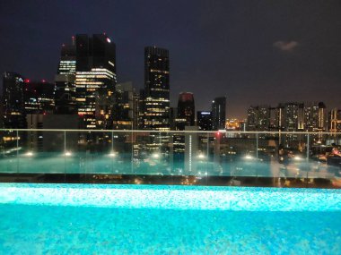 Singapur - 21 Ocak 2025: 21 Ocak 2025 tarihinde Singapur 'un Uzak Doğu Konukseverliği tarafından Singapur' daki The Clan Hotel 'de sonsuzluk yüzme havuzu. Havuzun modern iş gökdelenlerinin panoramik manzarası var.