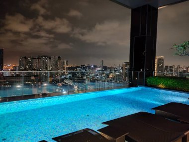 Singapur - 21 Ocak 2025: 21 Ocak 2025 tarihinde Singapur 'un Uzak Doğu Konukseverliği tarafından Singapur' daki The Clan Hotel 'de sonsuzluk yüzme havuzu. Havuzun modern iş gökdelenlerinin panoramik manzarası var.