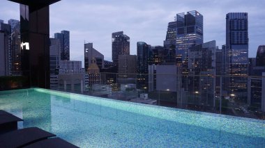 Singapur - 21 Ocak 2025: 21 Ocak 2025 tarihinde Singapur 'un Uzak Doğu Konukseverliği tarafından Singapur' daki The Clan Hotel 'de sonsuzluk yüzme havuzu. Havuzun modern iş gökdelenlerinin panoramik manzarası var.