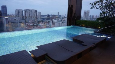 Singapur - 21 Ocak 2025: 21 Ocak 2025 tarihinde Singapur 'un Uzak Doğu Konukseverliği tarafından Singapur' daki The Clan Hotel 'de sonsuzluk yüzme havuzu. Havuzun modern iş gökdelenlerinin panoramik manzarası var.