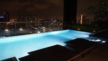 Singapur - 21 Ocak 2025: 21 Ocak 2025 tarihinde Singapur 'un Uzak Doğu Konukseverliği tarafından Singapur' daki The Clan Hotel 'de sonsuzluk yüzme havuzu. Havuzun modern iş gökdelenlerinin panoramik manzarası var.