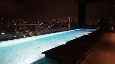 Singapur - 21 Ocak 2025: 21 Ocak 2025 tarihinde Singapur 'un Uzak Doğu Konukseverliği tarafından Singapur' daki The Clan Hotel 'de sonsuzluk yüzme havuzu. Havuzun modern iş gökdelenlerinin panoramik manzarası var.