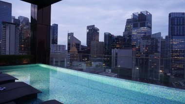 Singapur - 21 Ocak 2025: 21 Ocak 2025 tarihinde Singapur 'un Uzak Doğu Konukseverliği tarafından Singapur' daki The Clan Hotel 'de sonsuzluk yüzme havuzu. Havuzun modern iş gökdelenlerinin panoramik manzarası var.