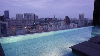 Singapur - 21 Ocak 2025: 21 Ocak 2025 tarihinde Singapur 'un Uzak Doğu Konukseverliği tarafından Singapur' daki The Clan Hotel 'de sonsuzluk yüzme havuzu. Havuzun modern iş gökdelenlerinin panoramik manzarası var.